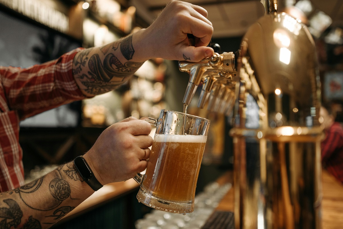 stock photo of a person pouring a pint of beer at a bar